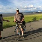Edgar and Sam biking on Tony Knowles Coastal Trail with Anchorage in background