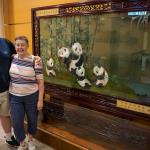 Sam and Julia in front of Hong Kong Museum of History silk screen showing pandas