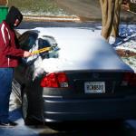 Sam clears snow and ice from his car