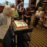 Grandmother blows out the "9" and "3" candles on her birthday cake