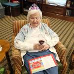 Grandmother enjoys a glass of wine at her birthday party