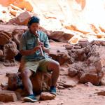 Navajo guide Quanah Johnson plays flute in opening of Hogan Cave in Monument Valley