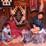 Navajo woman weaving in hogan during tour visit
