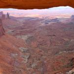 Full view of canyon through Mesa Arch in Canyonlands NP near Moab showing Washer Woman (high left) and La Sal Mountains on the horizon