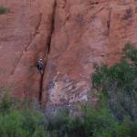 Rock climber as seen from jet boat on Colorado River